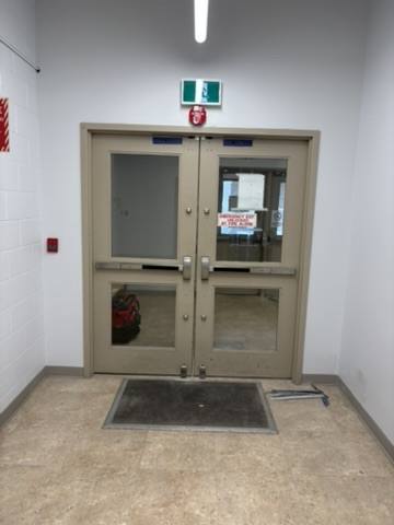 Commercial double exit doors with panic bar hardware serviced by 3 Point Lock Pros